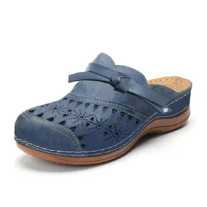 Detail view of blue hollow-out clog sandals with decorative knot strap and stitched sole
