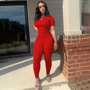 Full body view of a woman wearing a vibrant red ribbed short-sleeve top and leggings set