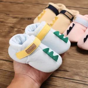 Gros plan sur des chaussures de marche souples pour bébé dinosaure en bleu clair
