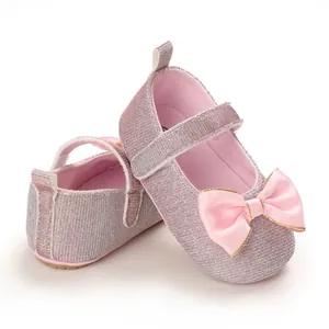 Detailaufnahme von rosa glitzernden Babyschuhen mit Satinschleife und Klettverschluss