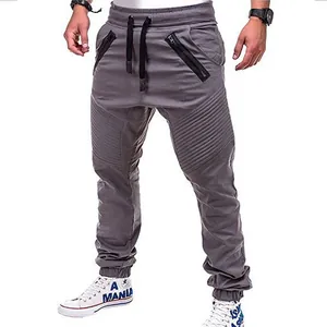 Detailansicht des gefalteten Kniedesigns und der Reißverschlüsse an grauen Jogginghosen.