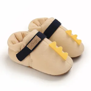 Vue détaillée de chaussures de marche jaunes pour bébé avec décoration de dinosaure mignon