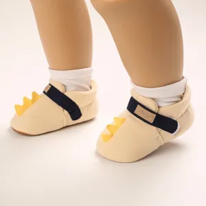 Vue détaillée de chaussures de marche souples pour bébé avec accents de dinosaure jaune