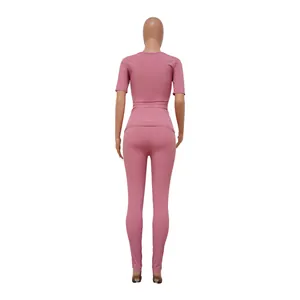 Back view of pink ribbed two-piece athletic set with short sleeve top and leggings.