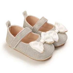 Detailaufnahme der silbernen Glitzer-Babyschuhe mit elegantem weißem Satin-Schleifen-Design