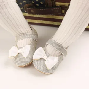 Nahaufnahme silberne Glitzer-Babyschuhe für Prinzessinnen mit weißer Satinschleife