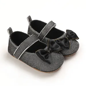 Detailansicht silberne Glitzer-Babyschuhe mit eleganten schwarzen Satinschleifen