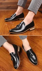 Detailed view of men's black leather loafers with stylish tassel accents and pointed toes.