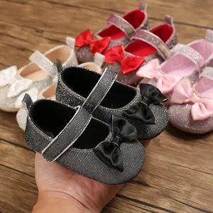 Detailansicht grauer Glitzer-Lauflernschuhe für Babys mit dekorativer schwarzer Schleife