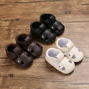 Close-up of baby walking sandals in three colors with soft soles on wooden background