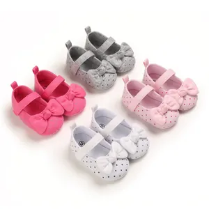 Variety of baby girl walker shoes with polka dots and bows in different colors.