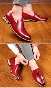 Detailed shot of burgundy leather tassel loafers for men with pointed toe design