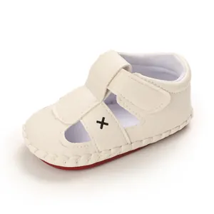 Detailed macro view of beige infant walker sandal with soft non-slip red sole.