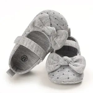 Detailed macro view of grey soft-sole baby girl princess shoes with bow and polka dots