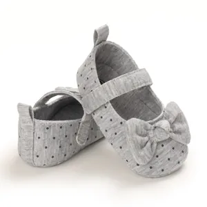 Detailed view of grey polka dot baby walking shoes with bow accent and soft sole