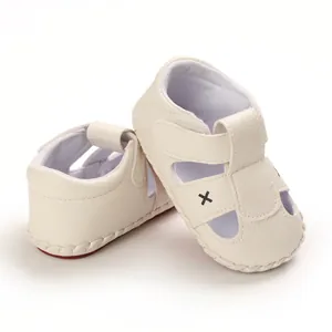 Close-up of cream soft-sole baby sandals with side cutouts and velcro strap