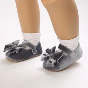 Macro detailed view of gray velvet baby girls princess shoes with large bow on doll feet