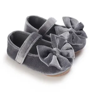 Detailed macro view of grey velvet baby girl walking shoes with a large decorative bow