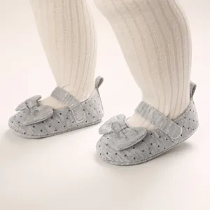 Detailed view of grey polka dot baby girls pre-walker shoes with soft soles and bows