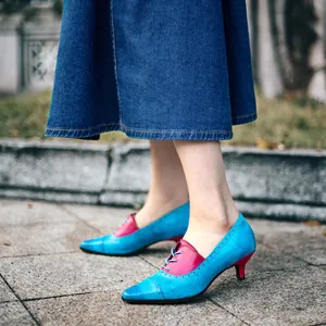 Seitenansicht der blauen und rosa Lederpumps mit Blumenprägung und Pfennigabsatz