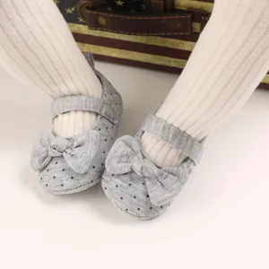 Close-up view of baby girl soft-sole walking shoes with polka dots and bow detail