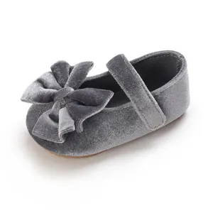 Close-up detail of soft grey velvet baby girl Mary Jane shoe with decorative bow