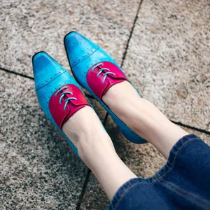 Nahaufnahme der eleganten blauen und roten Retro-Lederschuhe für Damen auf der Straße.