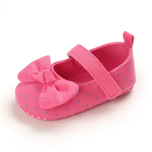 Detailed view of pink polka dot baby princess shoe with a soft sole and large bow decoration
