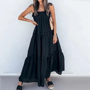 Full view of a stylish black tiered maxi dress featuring feminine tie-strap shoulders