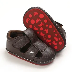 Detailed macro view of brown baby pre-walker sandals with non-slip red rubber sole