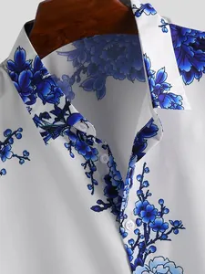 Detailed macro view of white men's shirt featuring blue ink-wash floral print