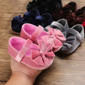 Detailed view of pink velvet baby girl walking shoes featuring a large decorative bow
