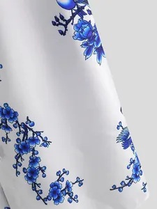 Close-up detail showing the blue ink wash plum blossom pattern on white shirt fabric