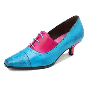 Detailansicht der blauen und roten Lederpumps mit Blumenprägung und spitzer Zehenpartie
