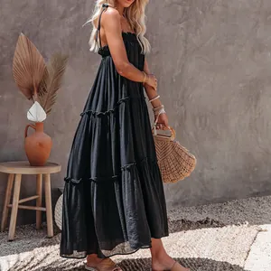 Chic bohemian black tiered maxi dress with thin spaghetti straps for summer beach wear.