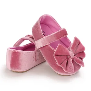 Close-up view of pink velvet baby girl Mary Janes featuring a large decorative bow