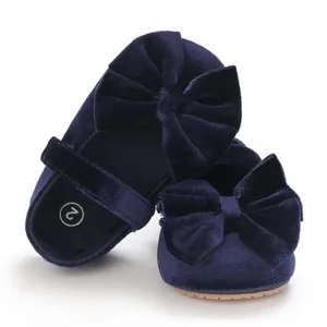 Close-up detail of navy blue velvet baby girl shoes featuring a large decorative bow