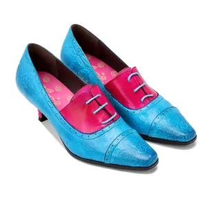 Detailansicht von echten Vintage-Lederschuhen mit blauer Blumenprägung und roten Akzenten