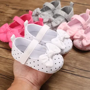 Detailed view of white polka dot baby princess shoes with a bow decoration