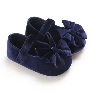 Close-up of navy blue velvet baby girl shoes with elegant bow decoration