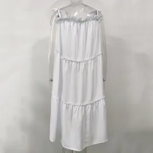 Detailed view of a white tiered sundress with ruffled edges and tie shoulder straps
