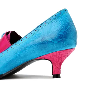 Detaillierte Nahaufnahme des geprägten Blumenmusters auf blauen und rosa Lederabsatzschuhen