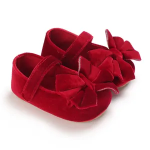 Close-up of red velvet baby princess walking shoes with elegant double bow detail