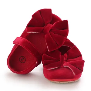 Detailed view of red velvet baby walking shoes featuring a large decorative bow