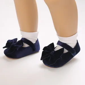 Close-up detail of dark blue velvet baby princess walking shoes with elegant bow accent