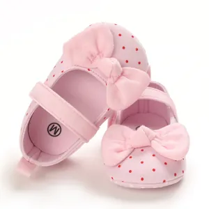 Close-up of pink polka dot baby girl princess shoes with soft soles and large bow