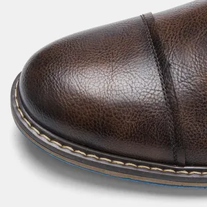Close-up detail of brown burnished leather texture and stitching on men's business shoes