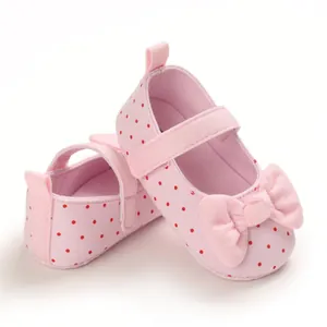 Close-up detail of soft-sole pink polka dot baby girl shoes featuring a cute decorative bow
