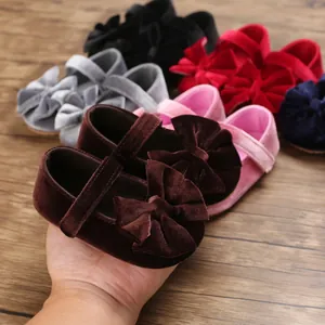 Detailed view of velvet baby girl shoes with large bow and soft sole
