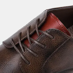 A detailed macro shot showing the textured leather finish of brown men's shoes.